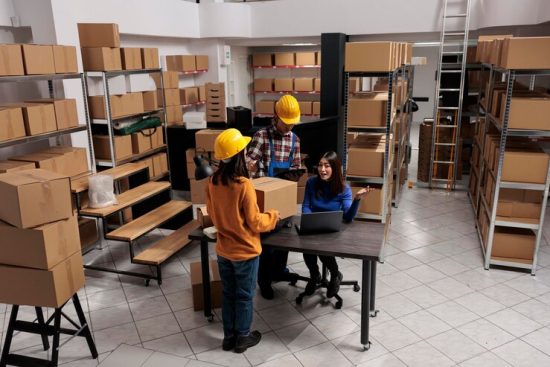 warehouse-package-handlers-doing-inventory-control-while-coworking-with-logistics-manager-asian-storehouse-employees-scanning-cardboard-box-creating-invoice-laptop_482257-71301