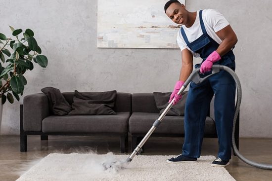 Cleaner-using-commercial-carpet-cleaner-on-carpet-in-home