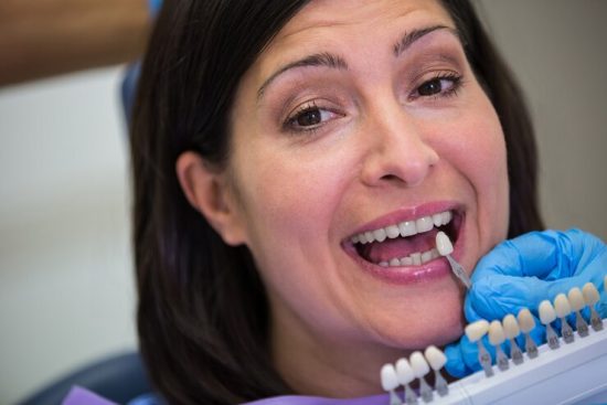 dentist-examining-female-patient-with-teeth-shades_107420-74151