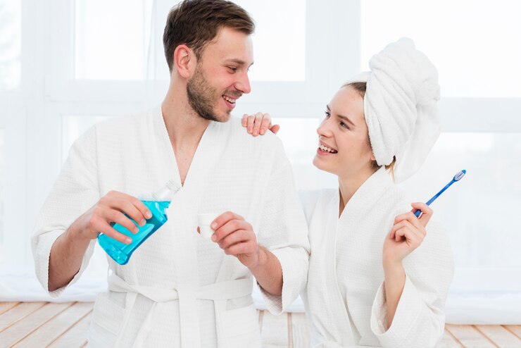 front-view-couple-bathrobes-with-mouthwash-toothbrush_23-2148389845