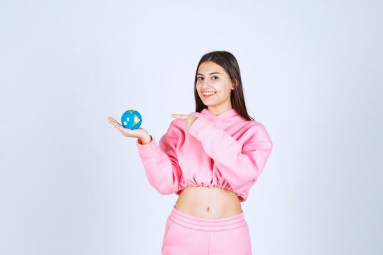 girl-pink-pajamas-holding-mini-globe-pointing-somewhere-it_144627-54261