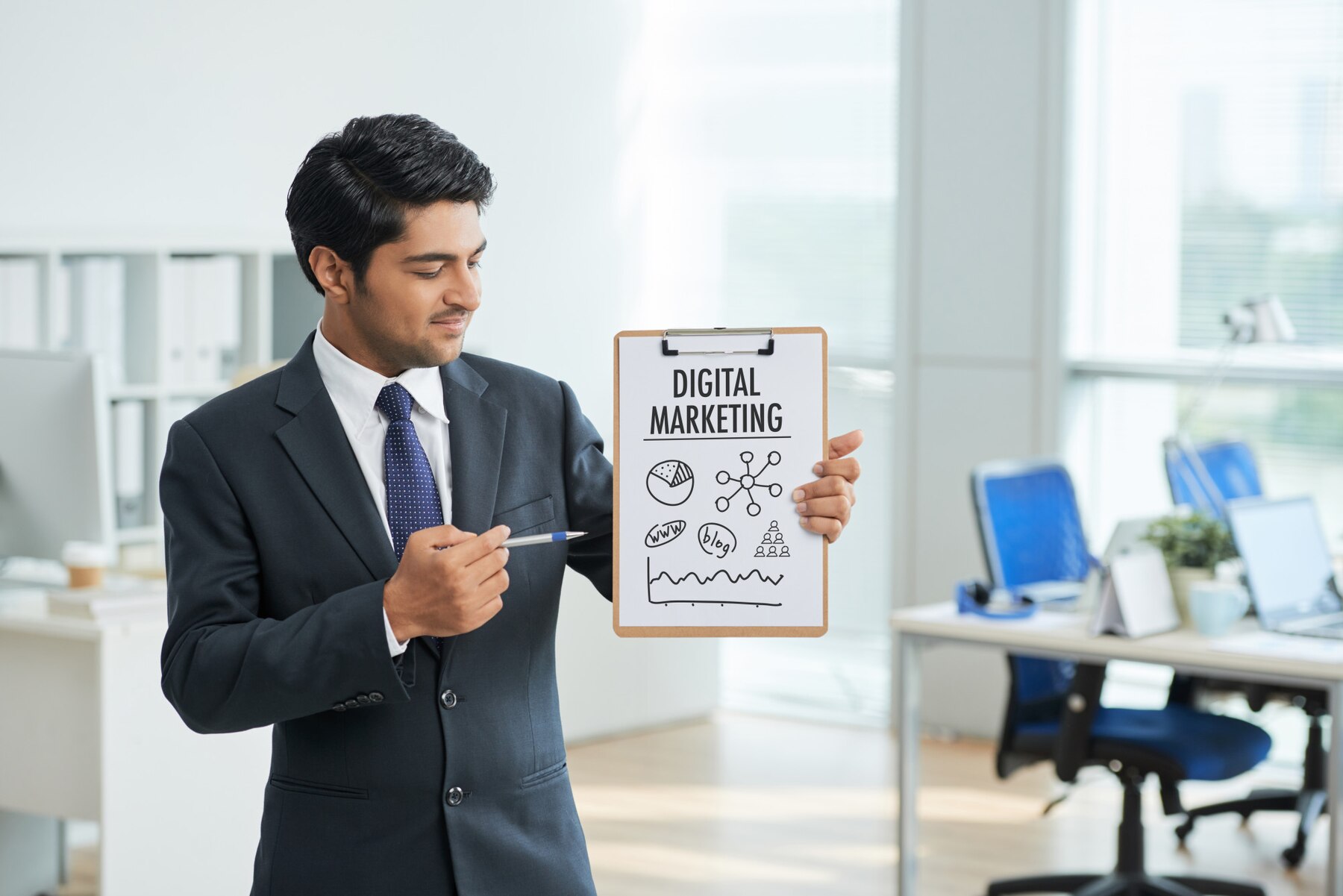 man-suit-standing-office-with-clipboard-pointing-poster-with-words_1098-17121