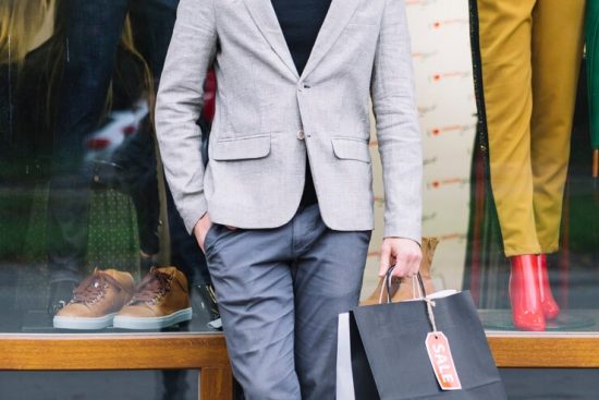 portrait-handsome-guy-holding-shopping-bags-hand-standing-front-window-display_23-2147968369