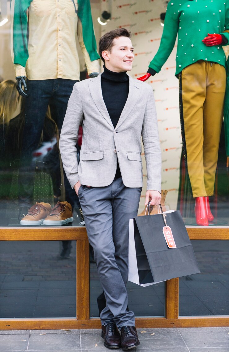 portrait-handsome-guy-holding-shopping-bags-hand-standing-front-window-display_23-2147968369