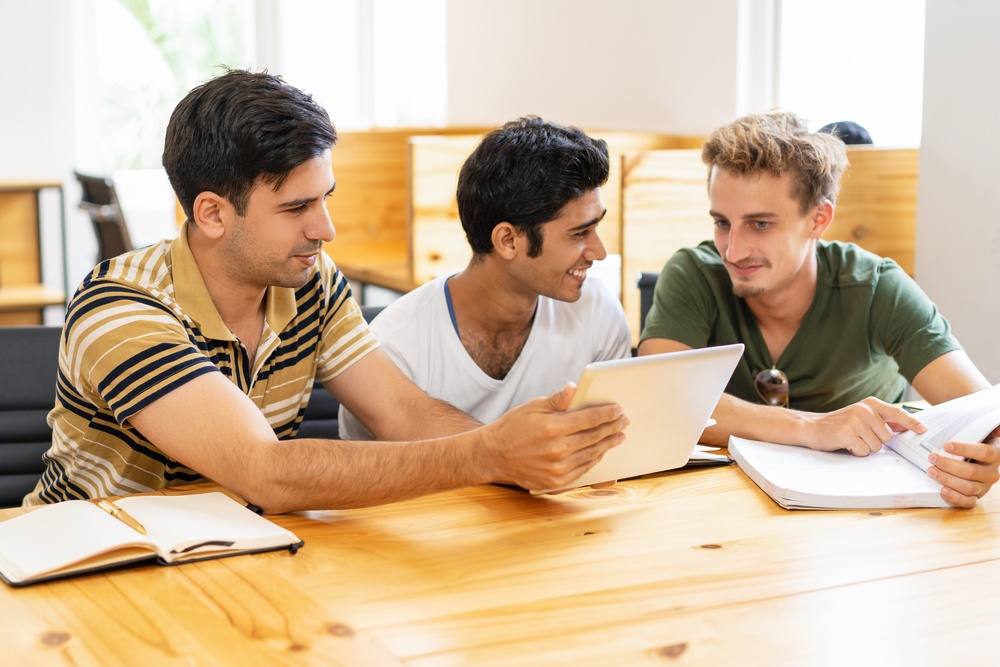 three-students-studying-using-tablet-chatting