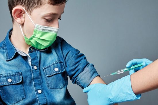 young-boy-being-vaccinated-wearing-surgical-mask-isolated-gray_145283-174