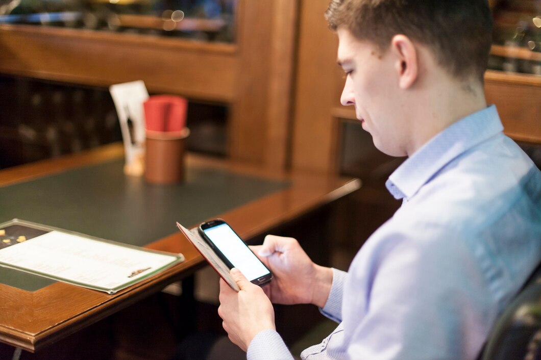 man-browsing-smartphone-restaurant_23-2147775822 (1)